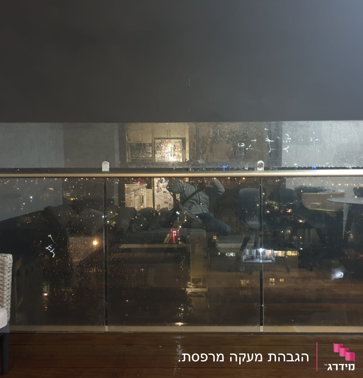 מעקה זכוכית עם טיפות מים בלילה